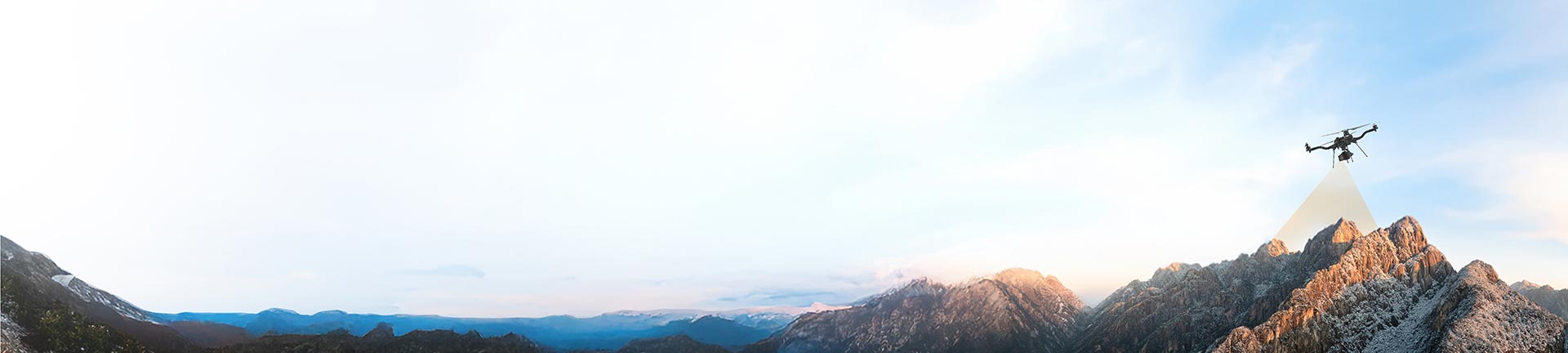 Vue panoramique de montagnes enneigées avec un drone les survolant pour capturer des images.