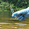 Main avec un gant bleu tenant un tube à essai avec un échantillon d'eau venant d'une rivière