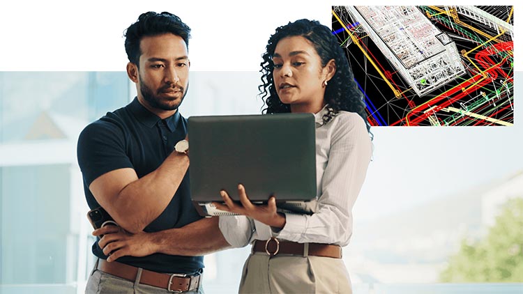 Deux professionnels debout ensemble et consultant des informations sur un ordinateur portable, avec un schéma technique coloré affiché dans le coin supérieur