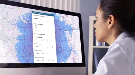 Femme qui consulte une grande carte sur un écran d’ordinateur