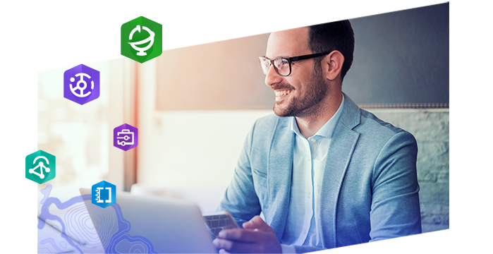 Jeune homme portant des lunettes et souriant en travaillant sur un ordinateur portable