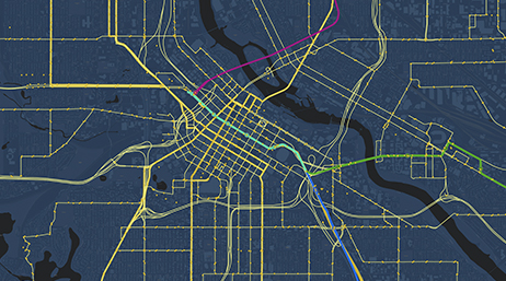 Carte gris foncé avec des routes en jaune et des lignes de transport en commun en rose, vert et bleu