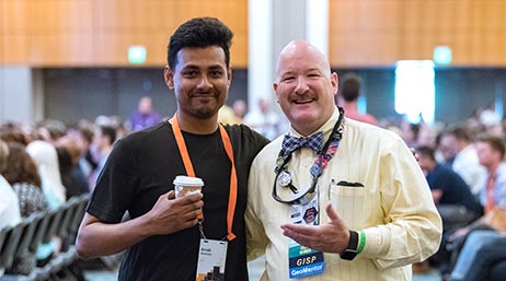 Deux personnes debout côte à côte et souriant dans un vaste espace événementiel