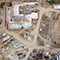  Image aérienne d’un chantier de construction avec des bâtiments partiellement construits et des équipements dispersés