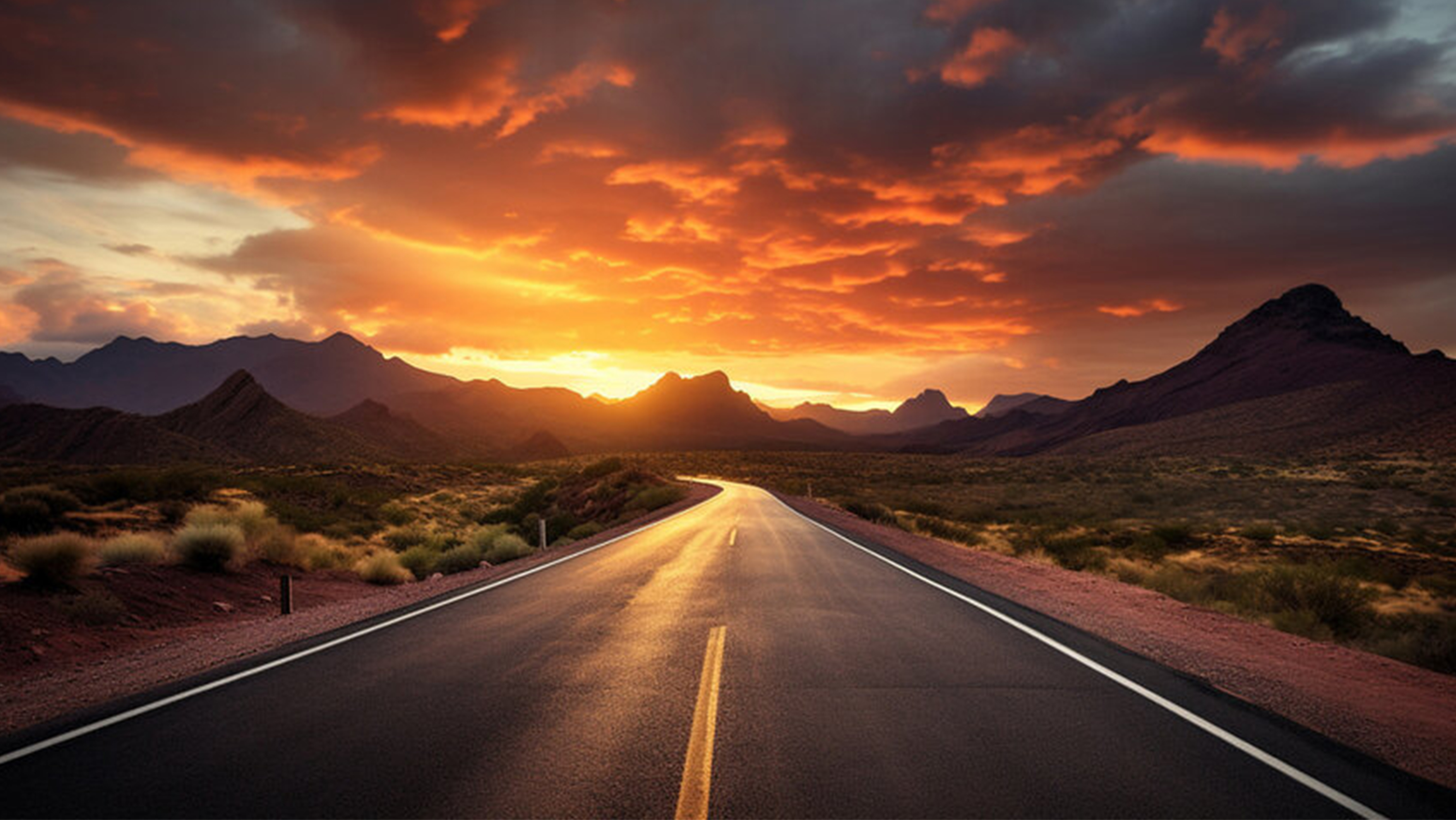 Route à deux voies dans un paysage désertique avec un coucher de soleil sur les montagnes au loin