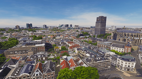 Image aérienne d’une ville historique tentaculaire se fondant dans une ville pleine de gratte-ciel au loin sous un ciel bleu brumeux