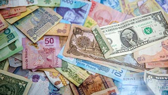 Différents billets monétaires du monde entier dont un billet vert de 1 $ des États-Unis