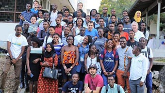 Groupe d’hommes et de femmes prenant une photo à l’extérieur d’un bâtiment