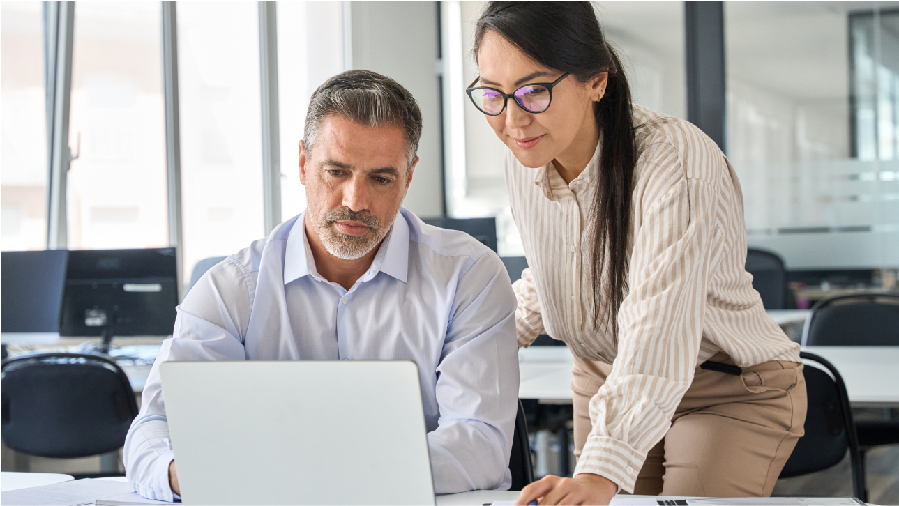 Un homme et une femme au bureau en pleine collaboration autour d’un ordinateur portable