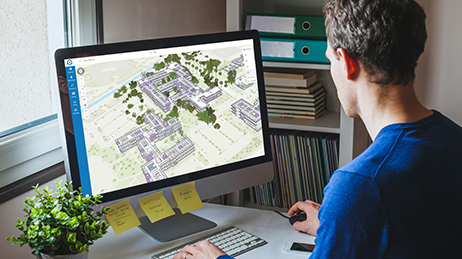 Employé en télétravail regardant un écran d'ordinateur qui affiche ArcGIS Indoors Viewer