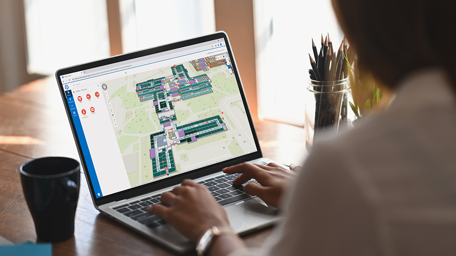 Personne qui télétravaille sur un ordinateur portable et qui utilise ArcGIS Indoors pour examiner l’utilisation de l’espace sur une carte indoor