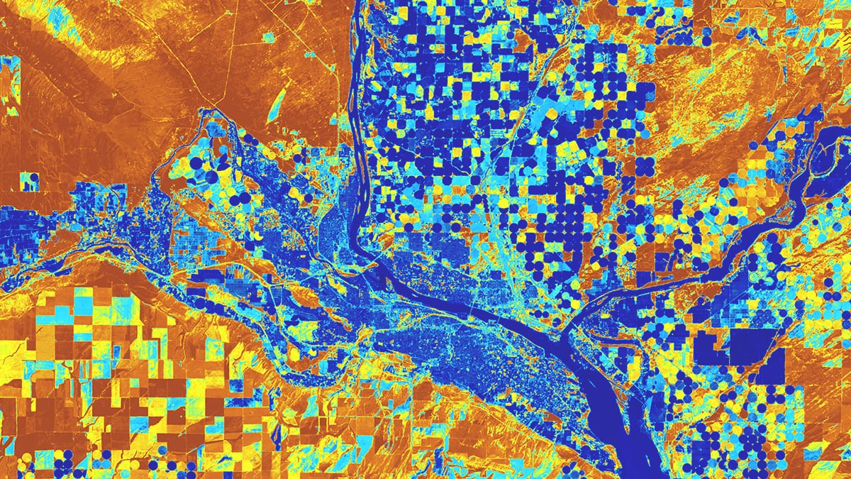 Une image satellite représente des parcelles de terre le long d’une rivière, avec des champs carrés et circulaires mis en évidence en bleu, orange et jaune.