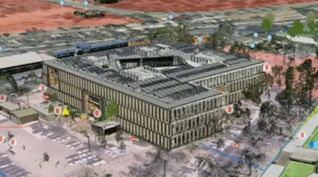 Vue aérienne d’un modèle de bâtiment 3D d’une importante structure hospitalière entourée de parkings et d’arbres