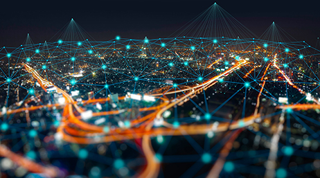 Image composite d’une ville vivement éclairée de nuit sous un ciel sombre sans étoiles, recouverte d’une grille bleue de points lumineux, connectés entre eux