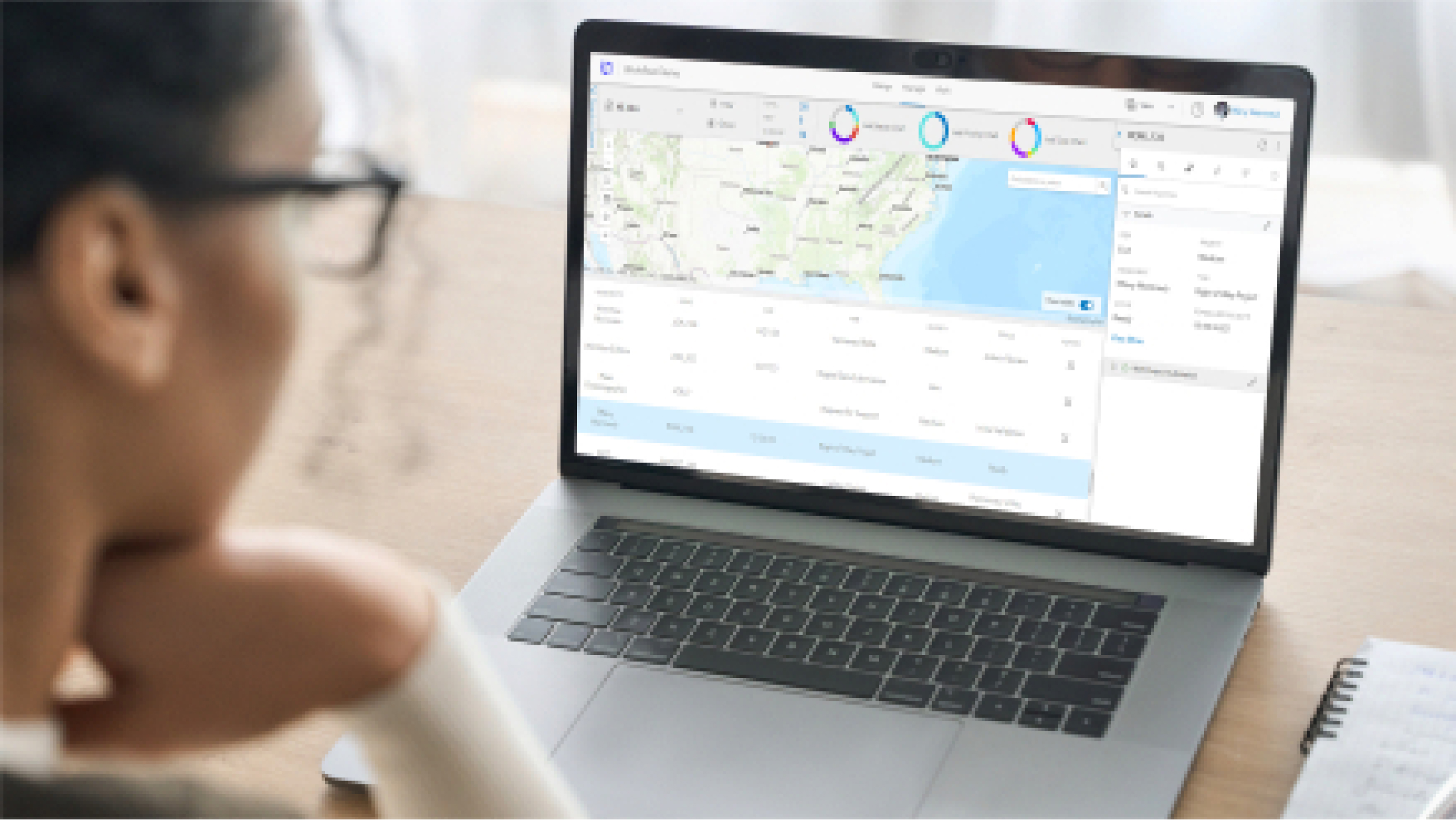 Personne regardant son ordinateur portable qui affiche un système de gestion de projets avec une liste de projets, des numéros de tâches et une carte des États-Unis