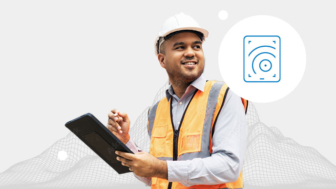 Homme portant un gilet orange et un casque de chantier blanc, tenant une tablette à la main avec une icône dans un cercle blanc en encart