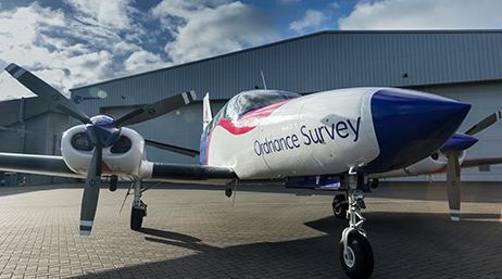 Avion Ordnance Survey au sol près d’un hangar