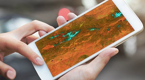 Deux mains utilisant un gros smartphone avec une carte sur lui 