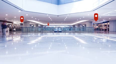 Niveau supérieur d’un centre commercial recouvert par trois icônes de symbole ponctuel de localisation rouges