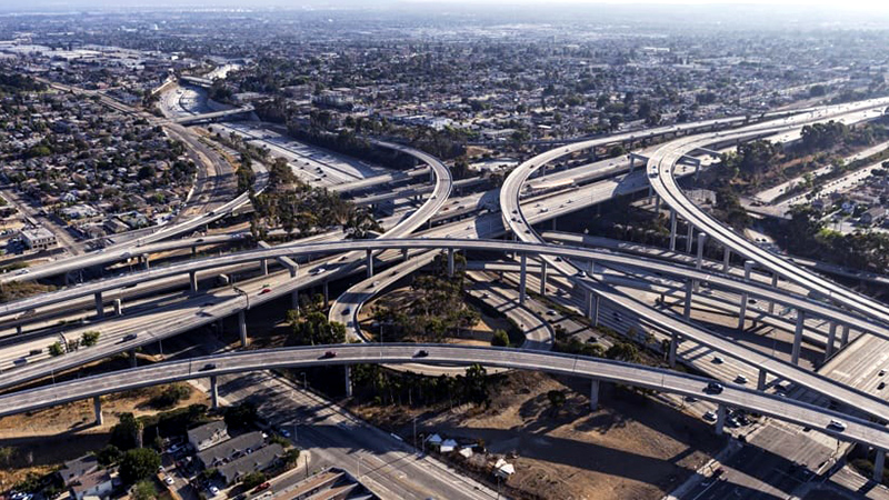 Vue aérienne d’un échangeur autoroutier complexe parsemé de voitures