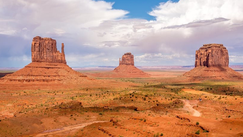 Trois formations rocheuses sous un ciel bleu nuageux