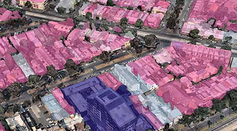 Quartier avec des maisons mises en évidence en rose et blanc et un grand bâtiment mis en évidence en violet