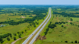 Vue aérienne d’une autoroute passant à travers des champs et des forêts