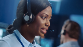 Femme dans un centre d’appels portant un casque, prête à répondre aux questions des clients et à les aider