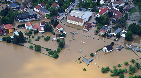 Image visualisant l’impact d’une inondation sur l’infrastructure publique, les services essentiels et les populations.