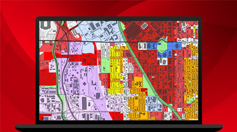 Ordinateur portable affichant une carte avec des sections rouges, orange, vertes, violettes et blanches dans ArcGIS Pro