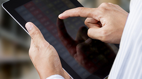 Photo en gros plan d’une paire de mains tenant et touchant une tablette