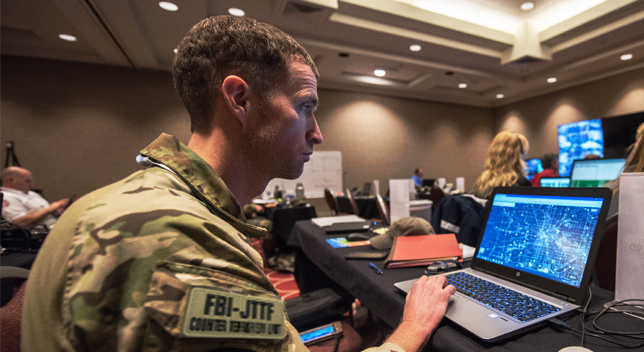 Personne en uniforme de combat regardant une carte numérique