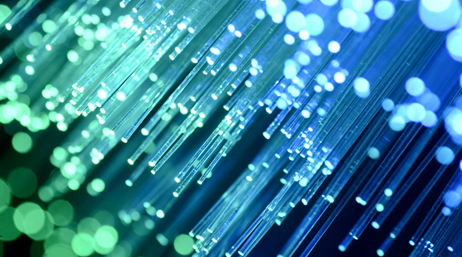Photo en très gros plan des extrémités d’un faisceau de câbles de fibre optique allumés et lumineux dans des nuances de bleu et de vert