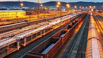 Dépôt de rails à la nuit tombante avec une chaîne de montagnes en arrière-plan