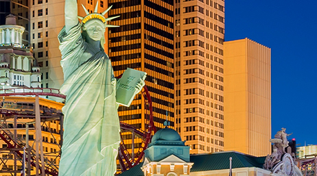 Vue de la ville de Las Vegas, avec de grands immeubles, des montagnes russes et la réplique de la statue de la Liberté