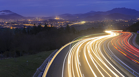 Time-lapse d'une autoroute chargée avec des traces lumineuses blanches et rouges de chaque côté