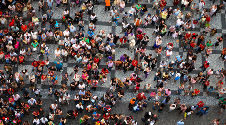 Photo aérienne carte d’une foule colorée occupant l’espace d’une place publique pavée