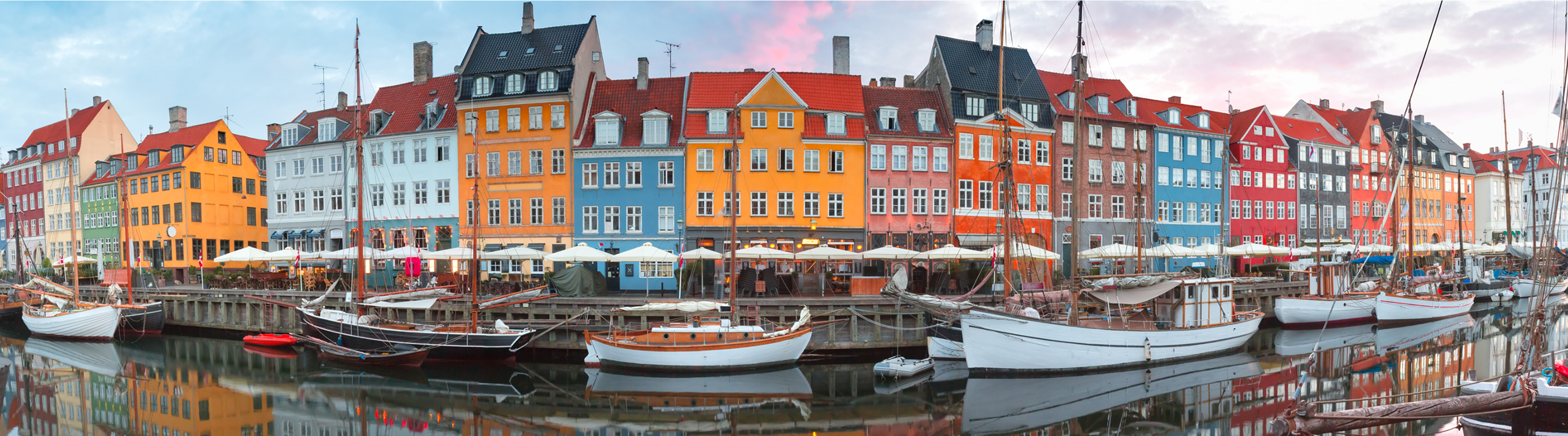 Bateaux amarrés dans un canal devant des bâtiments colorés à Copenhague