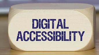 Un bloc de bois avec les mots « Accessibilité numérique » en lettres majuscules sur un côté