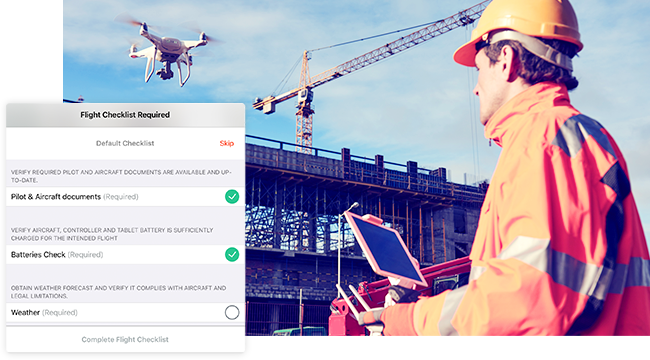 Pilote de drone en casque orange faisant voler un drone au-dessus d’un site de construction